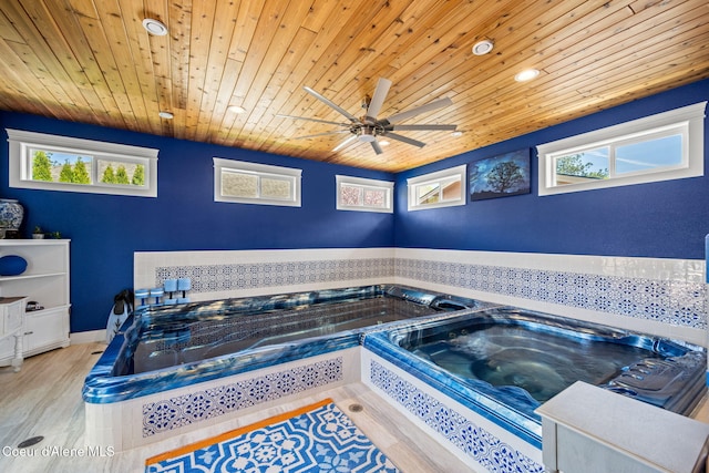 view of swimming pool with ceiling fan and an indoor hot tub