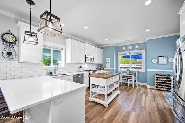 kitchen featuring open shelves, a sink, stainless steel appliances, white cabinetry, and backsplash