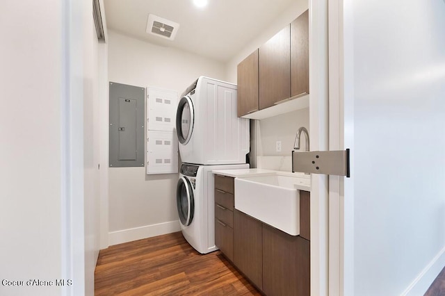 1579 W Riverstone Dr # 306, Coeur Dalene, ID 83814 - clothes washing area featuring visible vents, stacked washing maching and dryer, electric panel, baseboards, and cabinet space