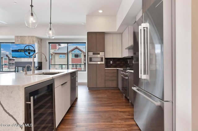 1579 W Riverstone Dr # 306, Coeur Dalene, ID 83814 - kitchen with dark wood finished floors, wine cooler, modern cabinets, a sink, and appliances with stainless steel finishes
