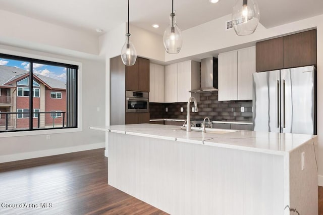 1579 W Riverstone Dr # 306, Coeur Dalene, ID 83814 - kitchen featuring stainless steel appliances, dark wood-style flooring, baseboards, decorative backsplash, and wall chimney range hood