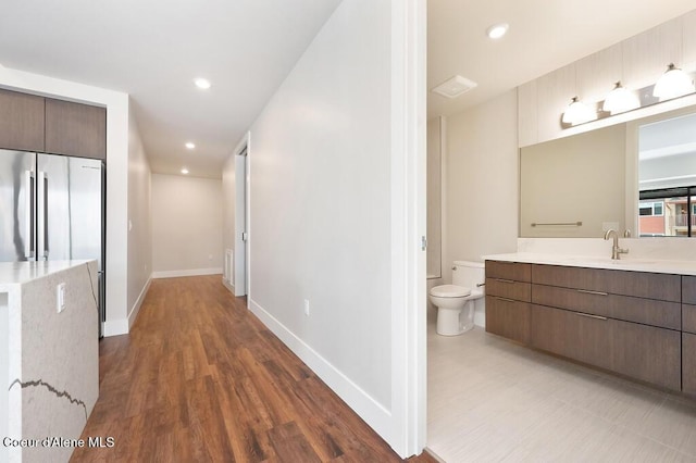 1579 W Riverstone Dr # 306, Coeur Dalene, ID 83814 - corridor featuring baseboards, wood finished floors, a sink, and recessed lighting