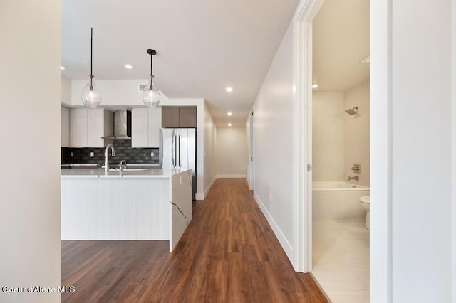 1579 W Riverstone Dr # 306, Coeur Dalene, ID 83814 - kitchen featuring tasteful backsplash, modern cabinets, light countertops, wall chimney exhaust hood, and freestanding refrigerator