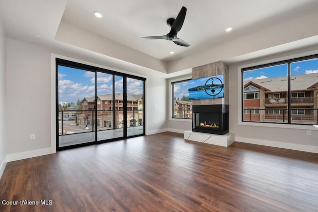 1579 W Riverstone Dr # 306, Coeur Dalene, ID 83814 - unfurnished living room featuring a fireplace, wood finished floors, baseboards, and ceiling fan