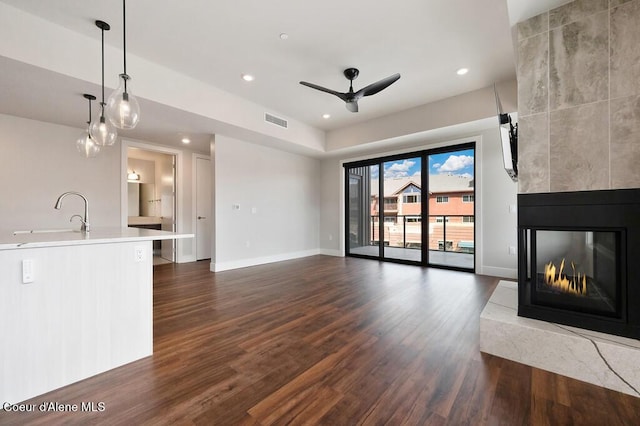 1579 W Riverstone Dr # 306, Coeur Dalene, ID 83814 - unfurnished living room featuring a multi sided fireplace, a sink, ceiling fan, dark wood finished floors, and visible vents