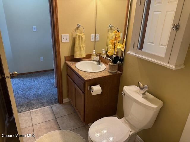 2359 N Alfalfa Loop, Post Falls, ID 83854 - half bathroom featuring baseboards, toilet, vanity, and tile patterned floors