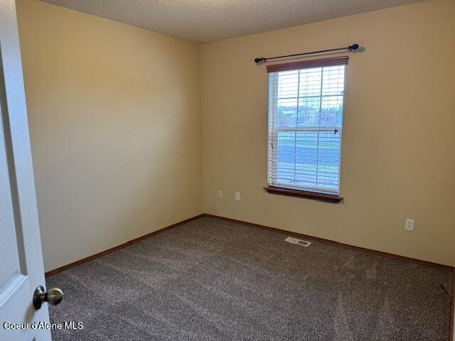 2359 N Alfalfa Loop, Post Falls, ID 83854 - unfurnished room featuring baseboards, visible vents, and carpet