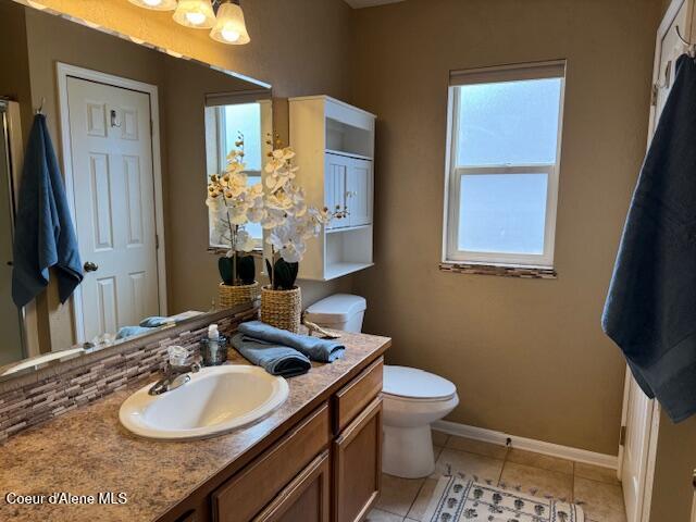 2359 N Alfalfa Loop, Post Falls, ID 83854 - bathroom with tile patterned floors, backsplash, toilet, vanity, and baseboards
