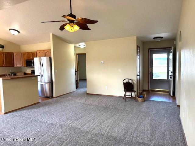 2359 N Alfalfa Loop, Post Falls, ID 83854 - unfurnished living room featuring lofted ceiling, carpet floors, a ceiling fan, and baseboards