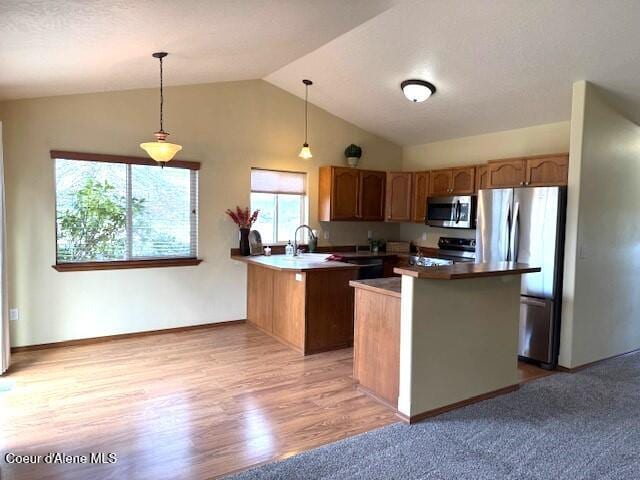 2359 N Alfalfa Loop, Post Falls, ID 83854 - kitchen with stainless steel appliances, a sink, light wood-type flooring, vaulted ceiling, and hanging light fixtures