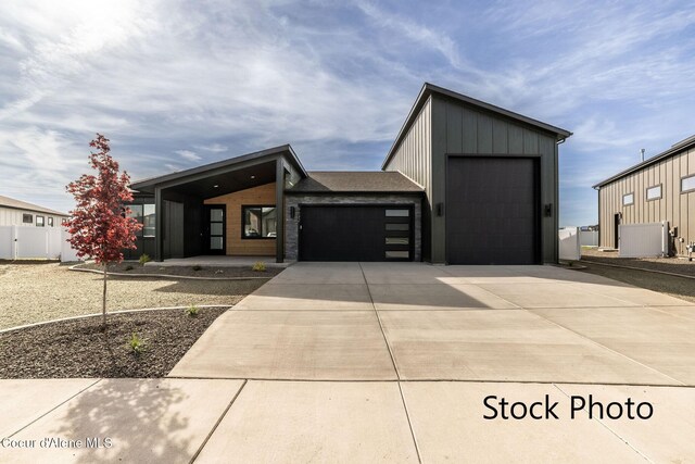 11506 N Clapton Ln, Rathdrum, ID 83858 - modern home with concrete driveway, an attached garage, board and batten siding, and fence