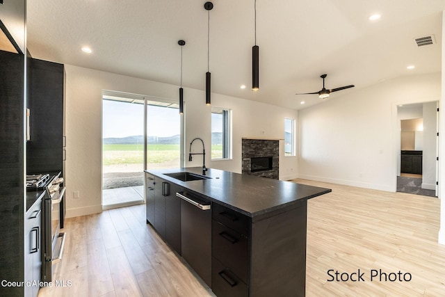 11506 N Clapton Ln, Rathdrum, ID 83858 - kitchen with a sink, appliances with stainless steel finishes, dark countertops, lofted ceiling, and a stone fireplace