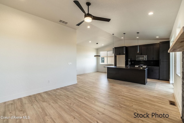 11506 N Clapton Ln, Rathdrum, ID 83858 - kitchen with stainless steel microwave, dark cabinets, dark countertops, a sink, and open floor plan