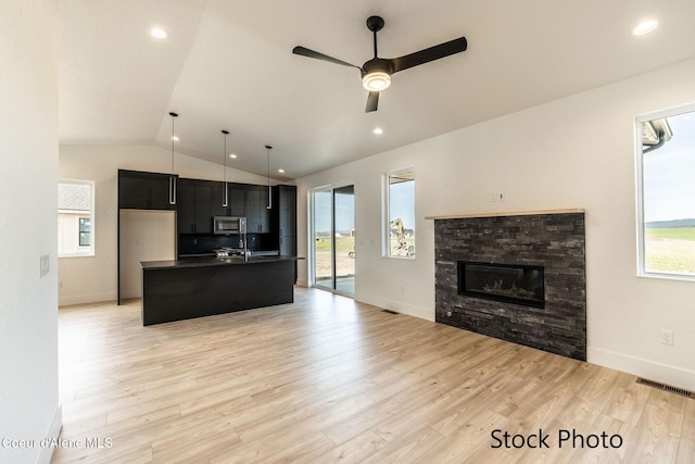 11506 N Clapton Ln, Rathdrum, ID 83858 - kitchen with stainless steel microwave, open floor plan, dark countertops, lofted ceiling, and dark cabinetry