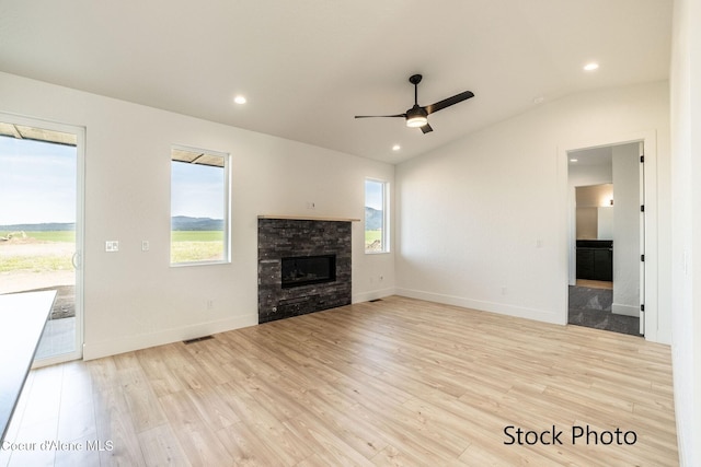 11506 N Clapton Ln, Rathdrum, ID 83858 - unfurnished living room featuring light wood-type flooring, a fireplace, healthy amount of natural light, ceiling fan, and lofted ceiling