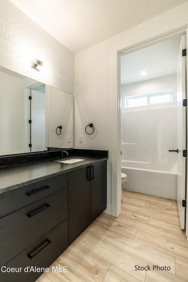 11506 N Clapton Ln, Rathdrum, ID 83858 - bathroom with vanity, wood finished floors, toilet, and bathtub / shower combination