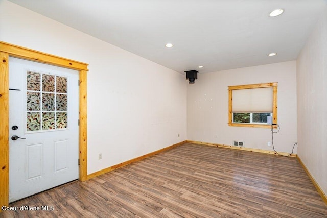 spare room featuring baseboards, wood finished floors, and visible vents