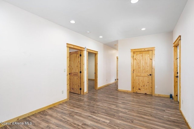 unfurnished room featuring recessed lighting, wood finished floors, and baseboards
