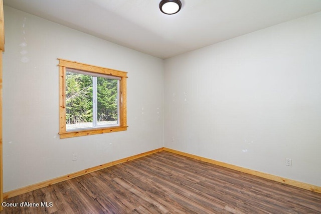 unfurnished room featuring baseboards and wood finished floors