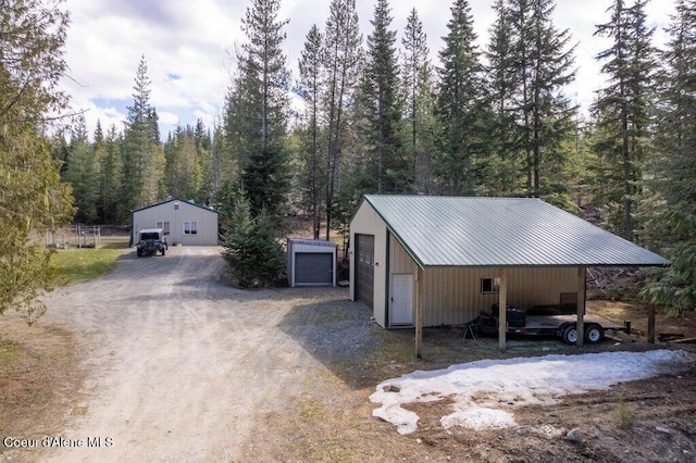 garage with a carport and a wooded view