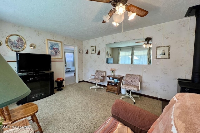 321 High St, Priest River, ID 83856 - living room featuring wallpapered walls, a wood stove, a ceiling fan, and a textured ceiling