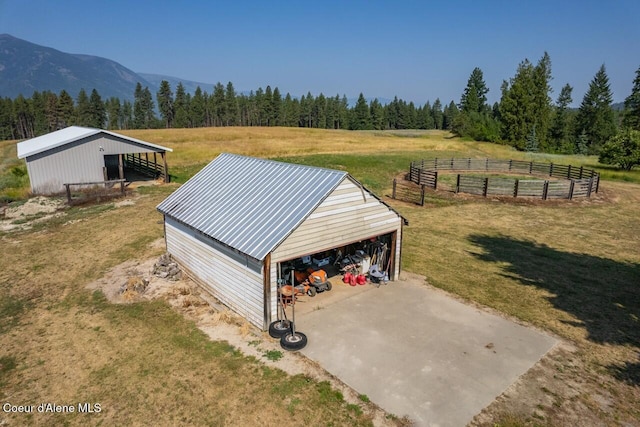 exterior space featuring fence, a yard, a wooded view, and a mountain view