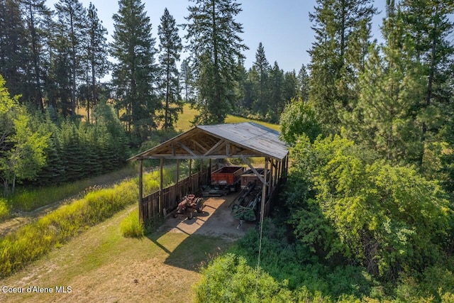 view of parking / parking lot with a wooded view and a carport