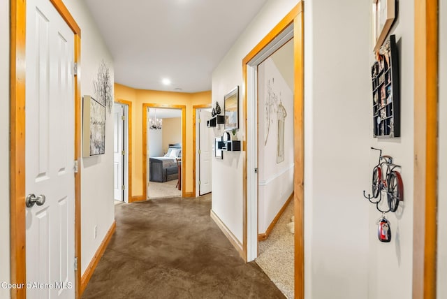 corridor with baseboards, concrete flooring, and recessed lighting