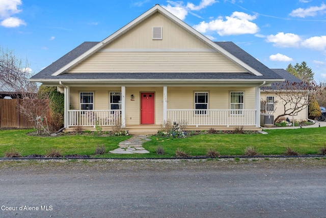 view of front of property with cooling unit, covered porch, and a shingled roof