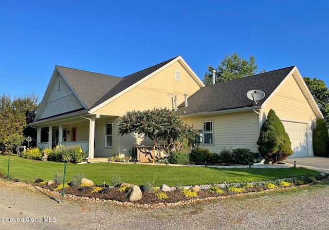 view of front of house with an attached garage, a front lawn, covered porch, and driveway