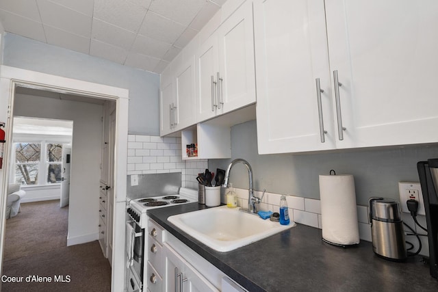 516 E Indiana Ave, Coeur Dalene, ID 83814 - kitchen featuring white cabinets, dark countertops, a sink, white electric range oven, and tasteful backsplash