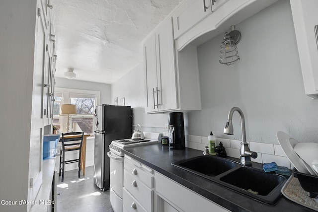 516 E Indiana Ave, Coeur Dalene, ID 83814 - kitchen featuring dark countertops, electric stove, a sink, white cabinetry, and freestanding refrigerator