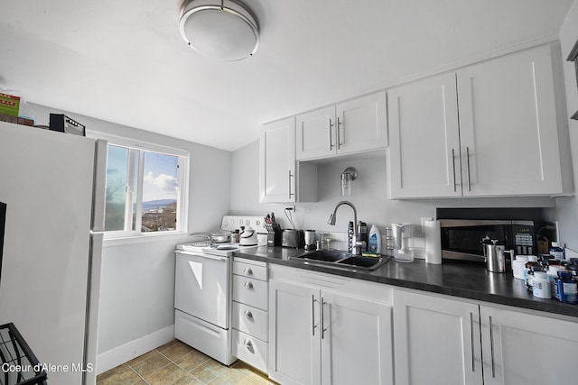 516 E Indiana Ave, Coeur Dalene, ID 83814 - kitchen with white cabinets, dark countertops, a sink, white appliances, and baseboards