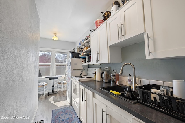 516 E Indiana Ave, Coeur Dalene, ID 83814 - kitchen with white range with electric cooktop, dark countertops, open shelves, a sink, and white cabinets