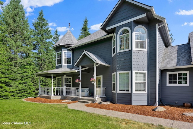 3825 E English Point Rd, Hayden, ID 83835 - victorian house with covered porch, a front lawn, and a shingled roof