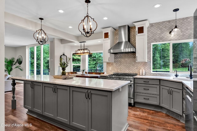 3825 E English Point Rd, Hayden, ID 83835 - kitchen featuring wall chimney exhaust hood, gray cabinets, high end range, a kitchen island, and glass insert cabinets