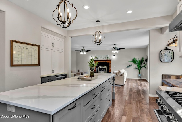 3825 E English Point Rd, Hayden, ID 83835 - kitchen with ceiling fan, a chandelier, gray cabinetry, stove, and a center island