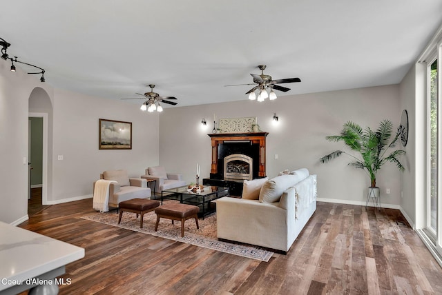 3825 E English Point Rd, Hayden, ID 83835 - living area featuring arched walkways, wood finished floors, a ceiling fan, and a fireplace with raised hearth