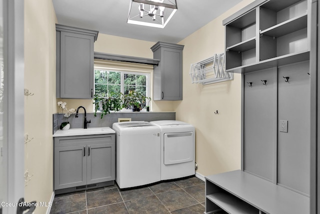 3825 E English Point Rd, Hayden, ID 83835 - laundry area featuring washing machine and clothes dryer, cabinet space, dark stone finish floors, and a chandelier