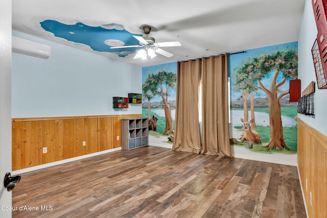 3825 E English Point Rd, Hayden, ID 83835 - spare room with a wall mounted air conditioner, wood finished floors, ceiling fan, a wainscoted wall, and wooden walls