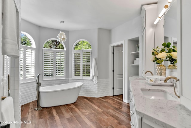 3825 E English Point Rd, Hayden, ID 83835 - full bathroom with healthy amount of natural light, double vanity, a soaking tub, and wainscoting