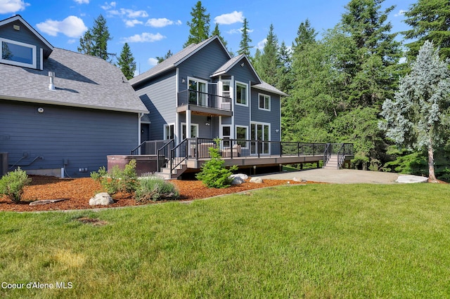 3825 E English Point Rd, Hayden, ID 83835 - back of property featuring a balcony, a yard, a wooden deck, a shingled roof, and a patio