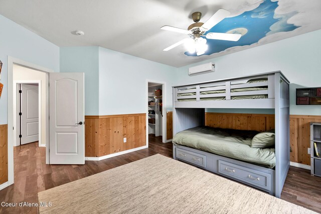 3825 E English Point Rd, Hayden, ID 83835 - bedroom featuring a wainscoted wall, a wall mounted air conditioner, wood finished floors, wooden walls, and a spacious closet