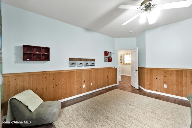 3825 E English Point Rd, Hayden, ID 83835 - sitting room with wainscoting, wood finished floors, wood walls, and ceiling fan