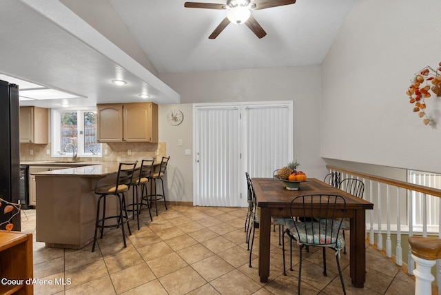 dining area featuring a ceiling fan, vaulted ceiling, and light tile patterned flooring