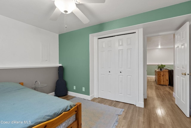 bedroom with a ceiling fan, baseboards, a closet, and light wood-style flooring