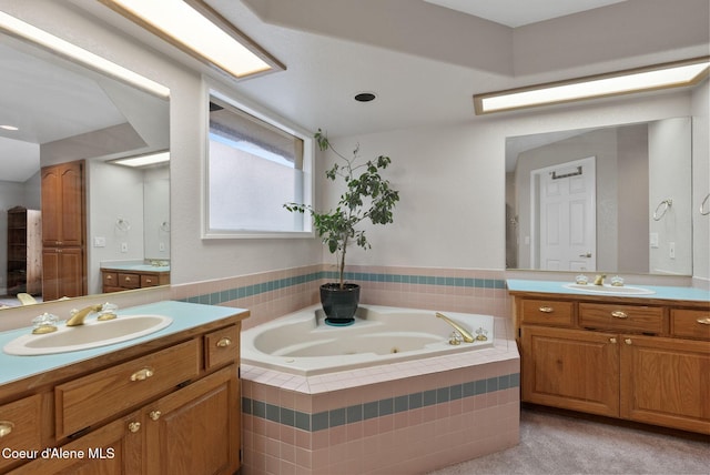 bathroom featuring a whirlpool tub, two vanities, and a sink