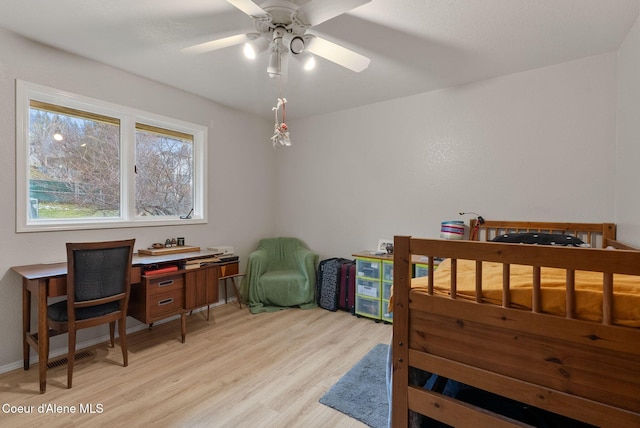 bedroom with baseboards, a ceiling fan, visible vents, and light wood-style flooring