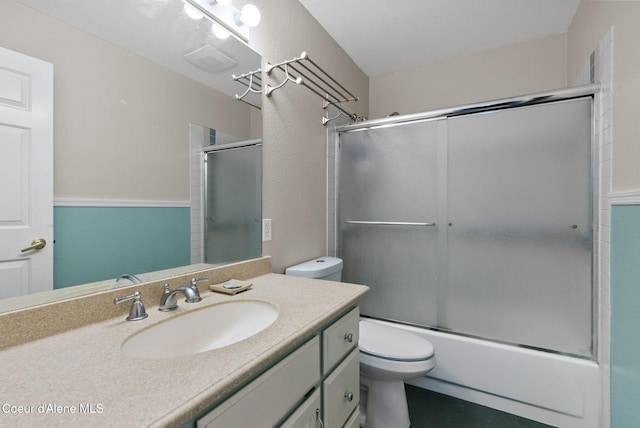 bathroom with vanity, bath / shower combo with glass door, and toilet