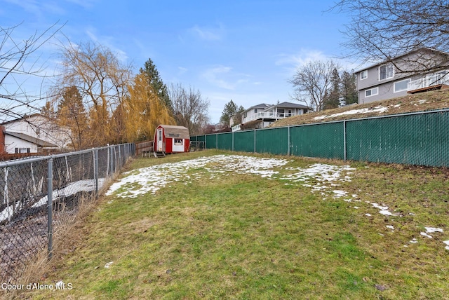 view of yard featuring a fenced backyard, an outbuilding, and a storage shed